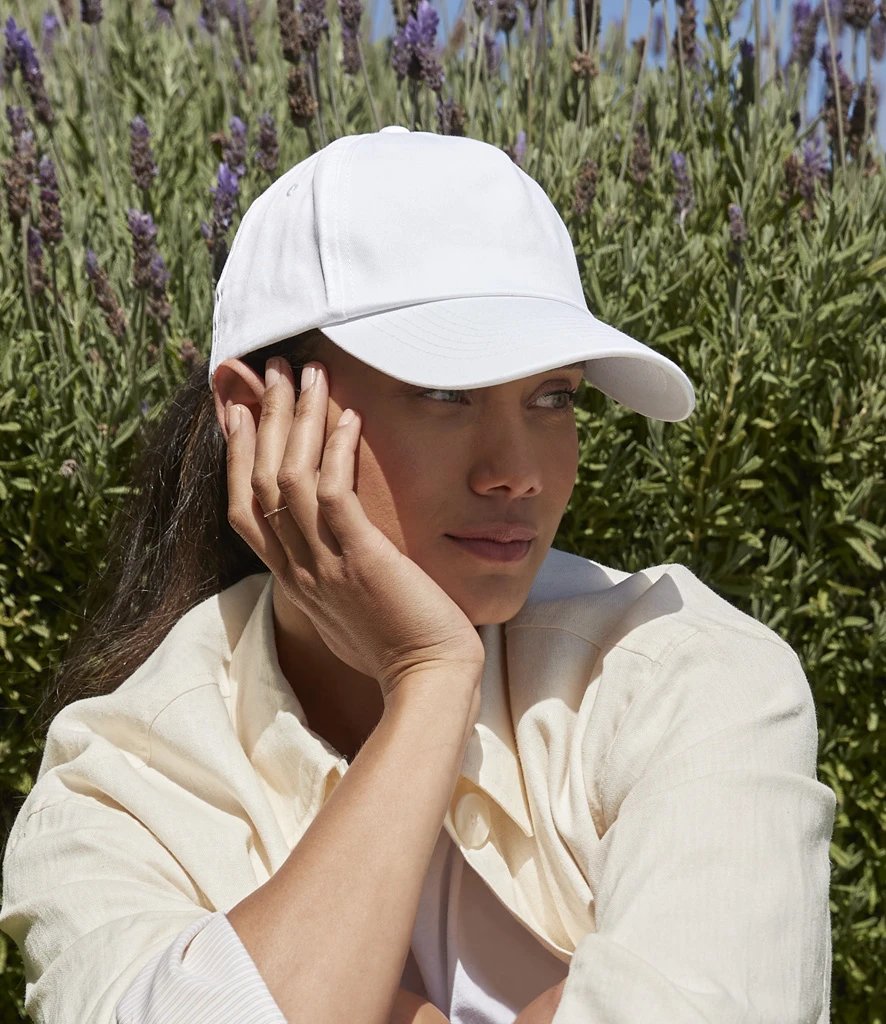 Model wearing a white Beechfield Authentic 5 panel cap outdoors