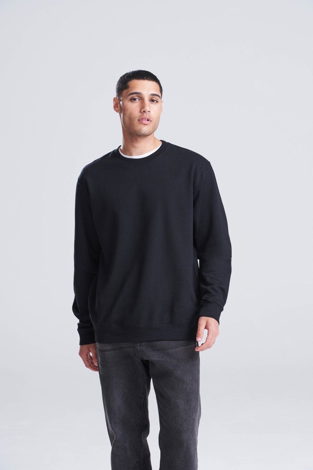 Model wearing a black AWDis Sweatshirt, front view