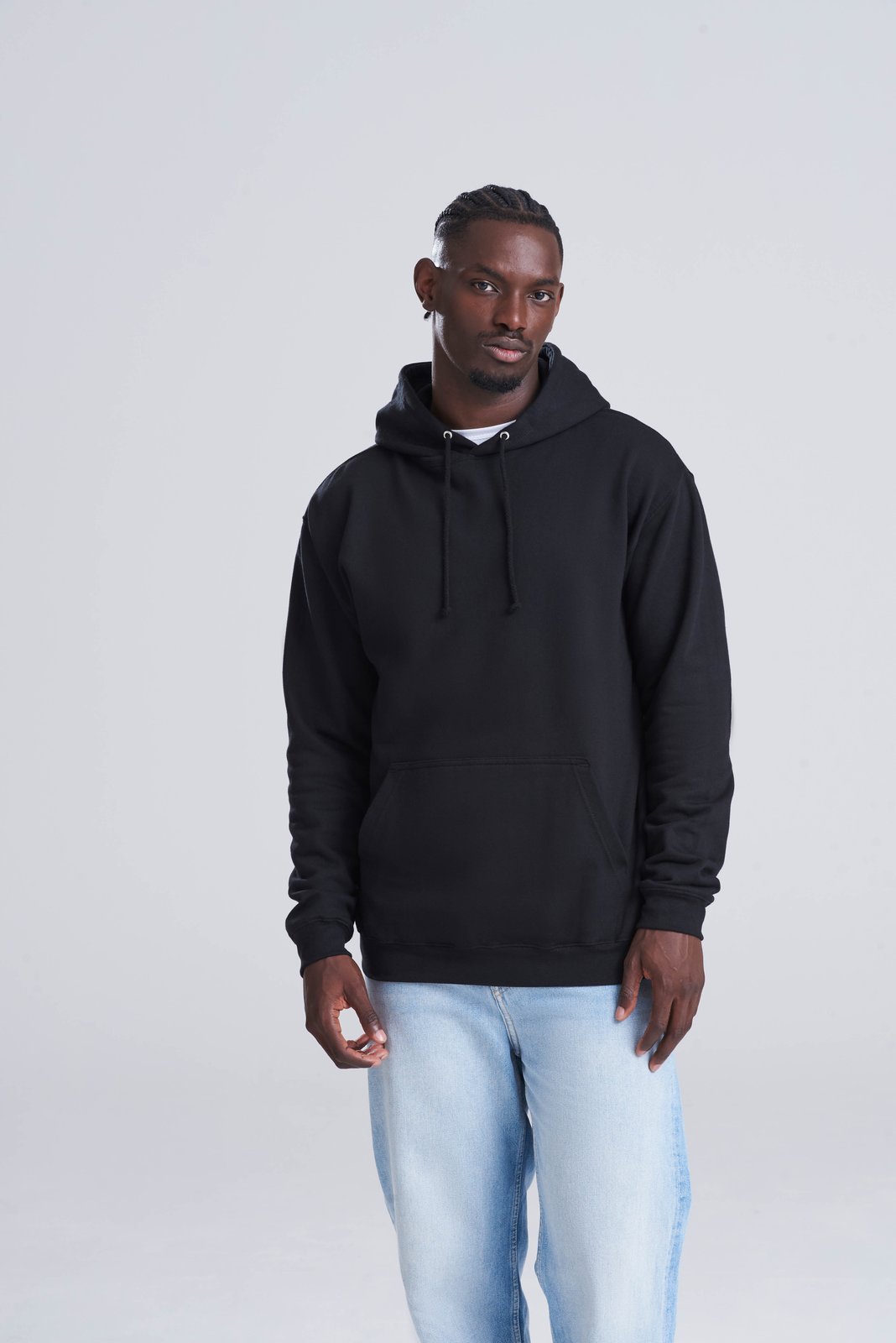 Model wearing a black AWDis College Hoodie with light blue jeans