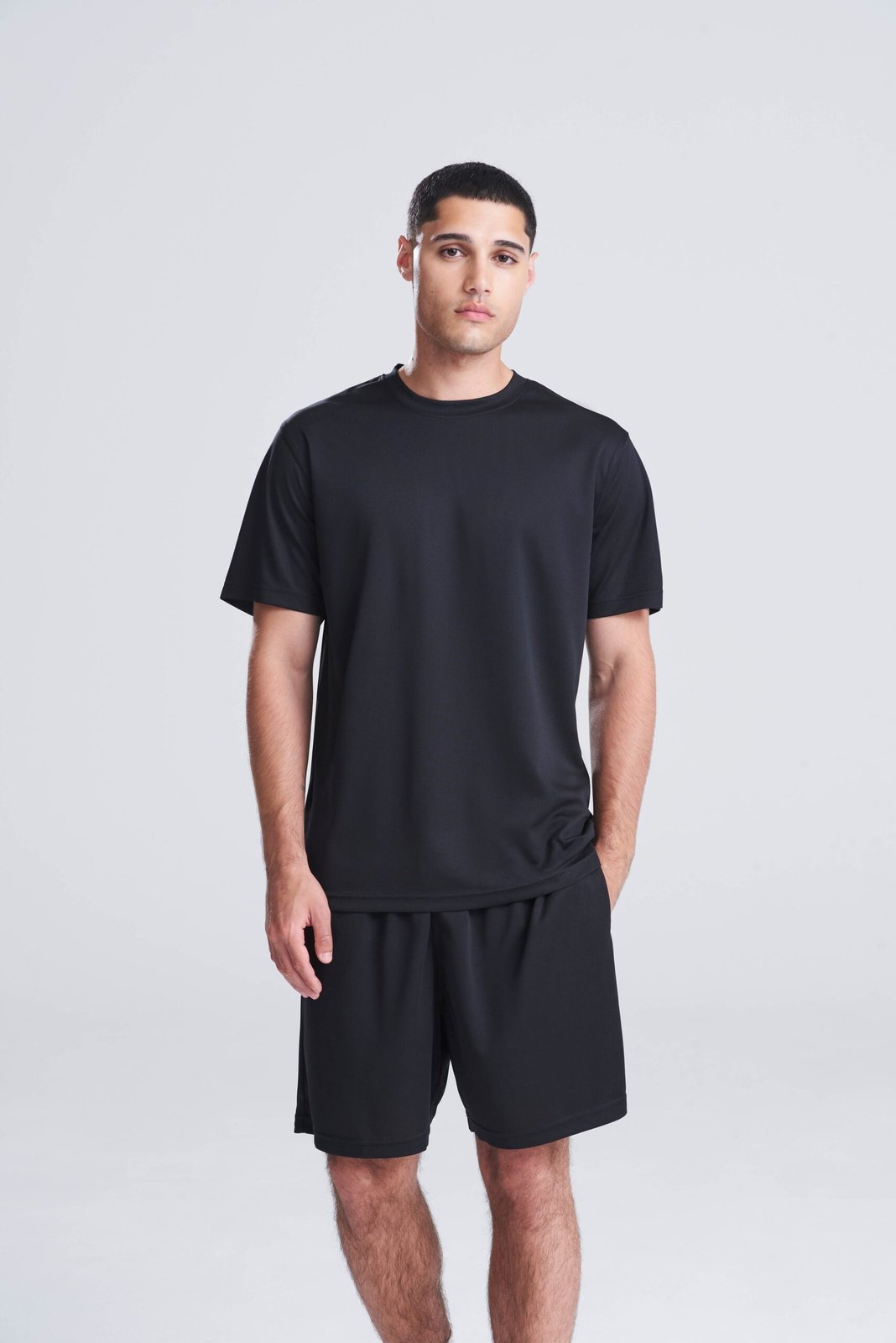 Model wearing a black AWDis Cool T-shirt, front view