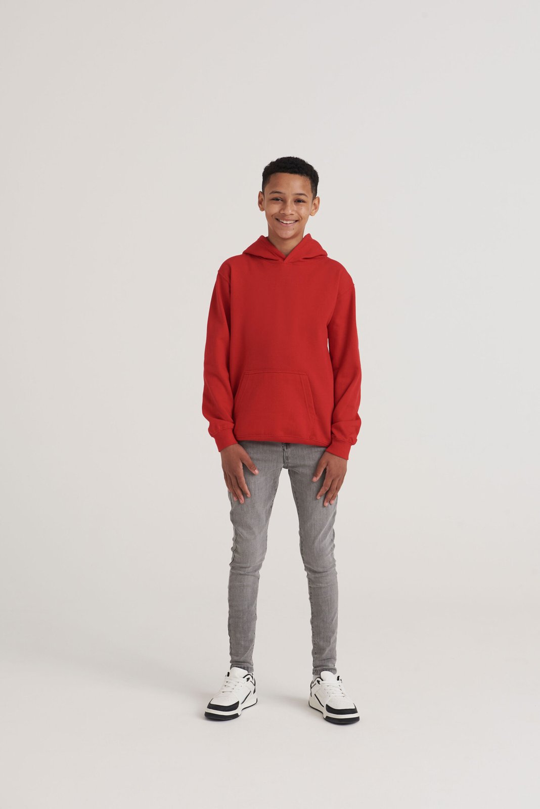 Child wearing a red AWDis Kids Hoodie, front view