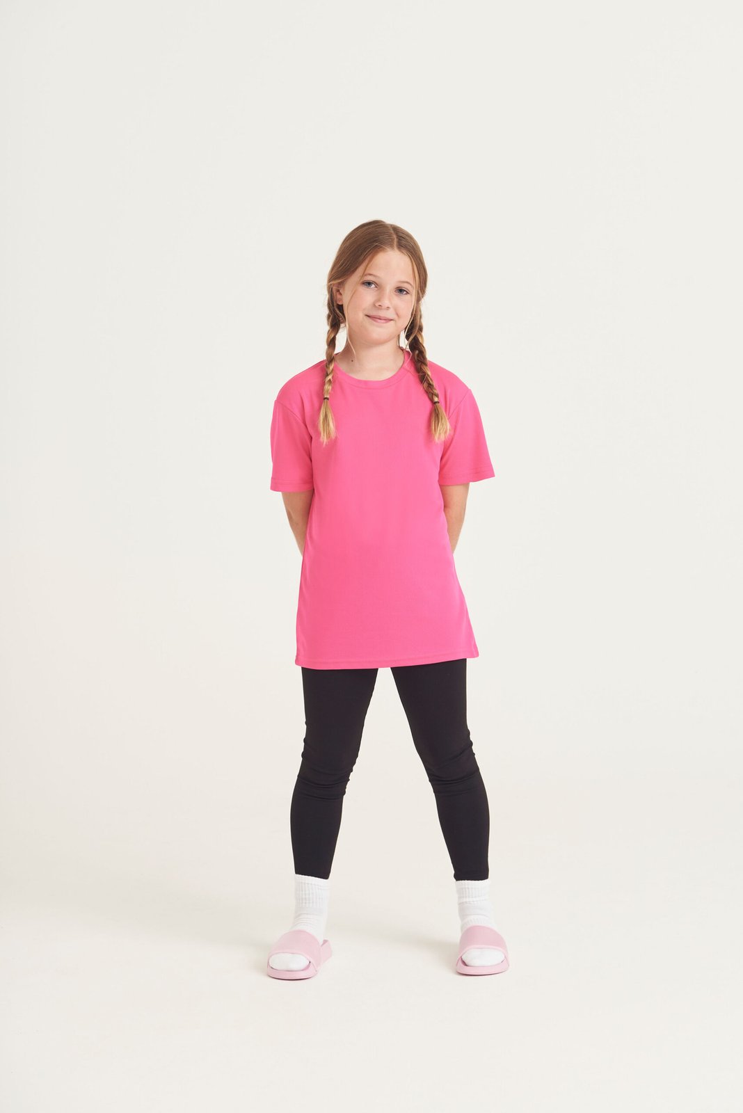 Child wearing a pink AWDis Kids Cool T-shirt, front view