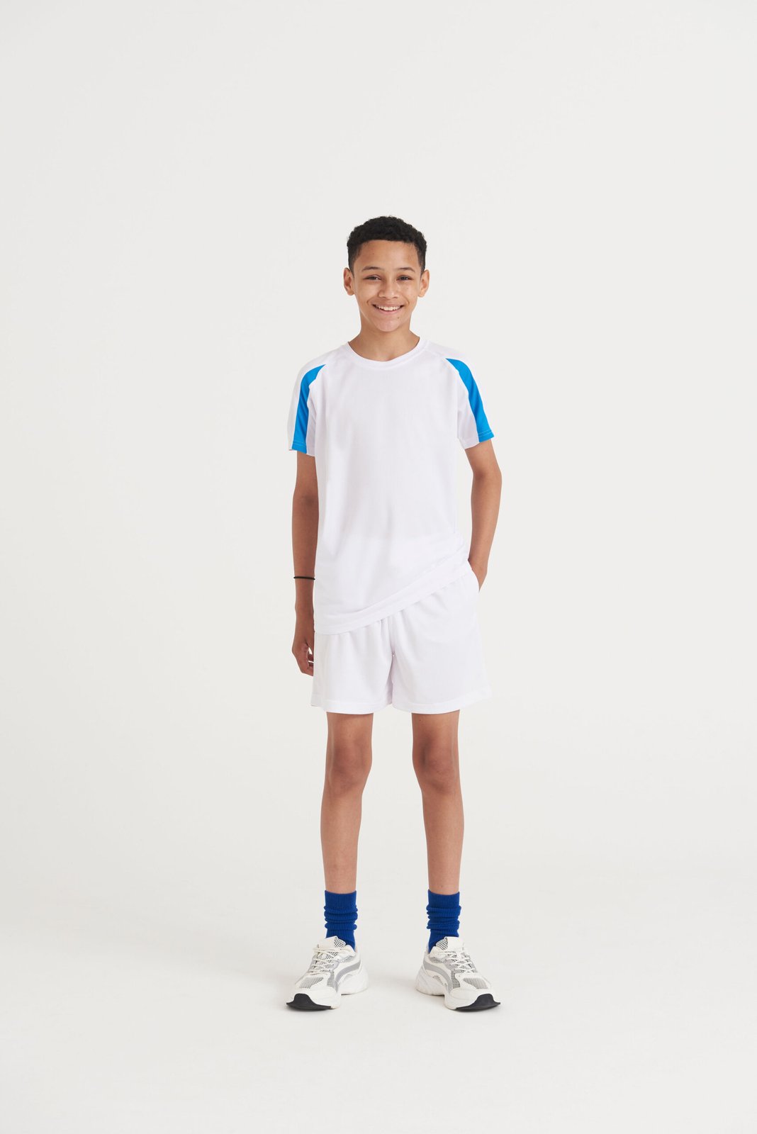 Child wearing a white AWDis Kids Cool Contrast T-shirt with blue side panels, front view