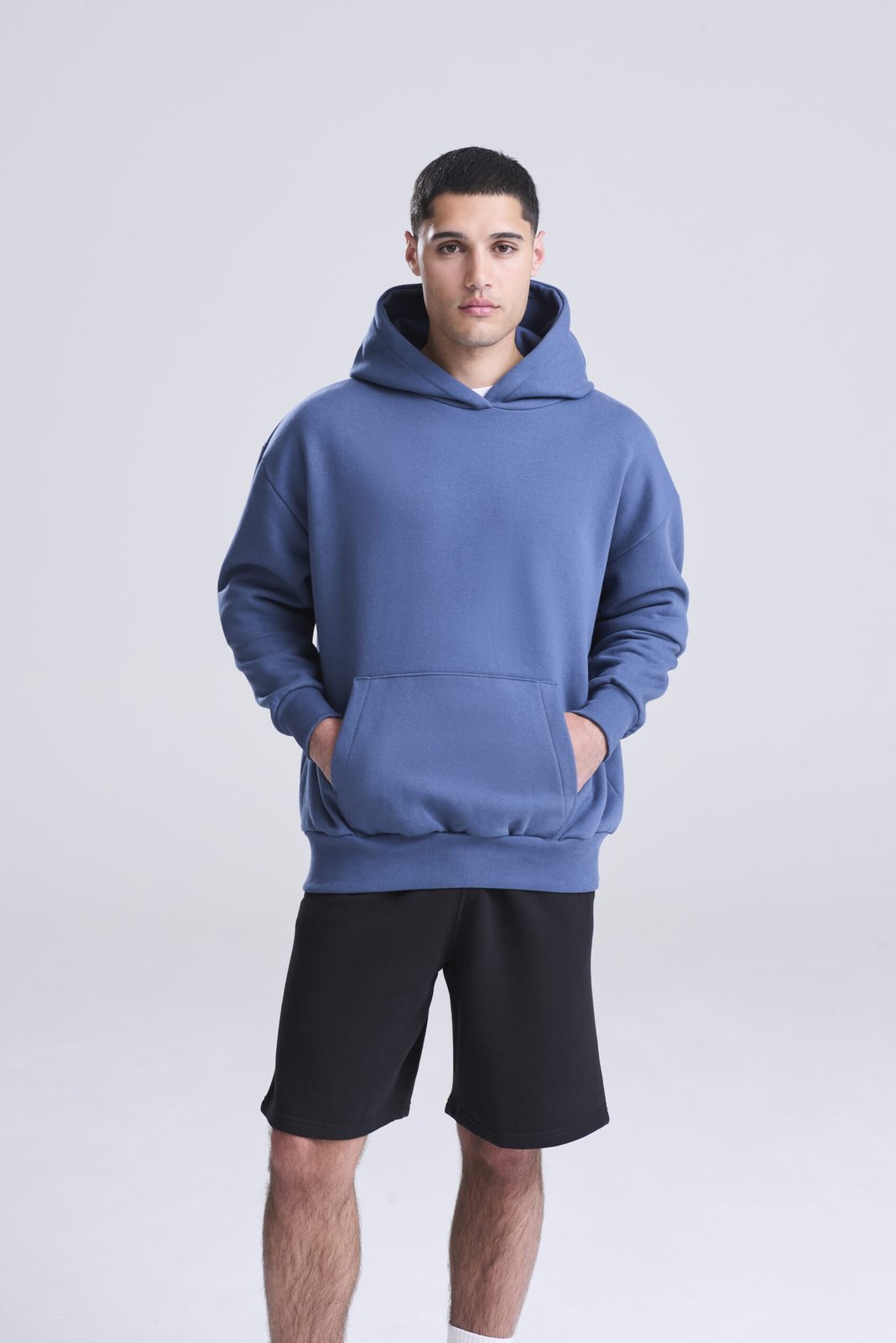 Model wearing a blue AWDis Signature Heavyweight Hoodie, front view